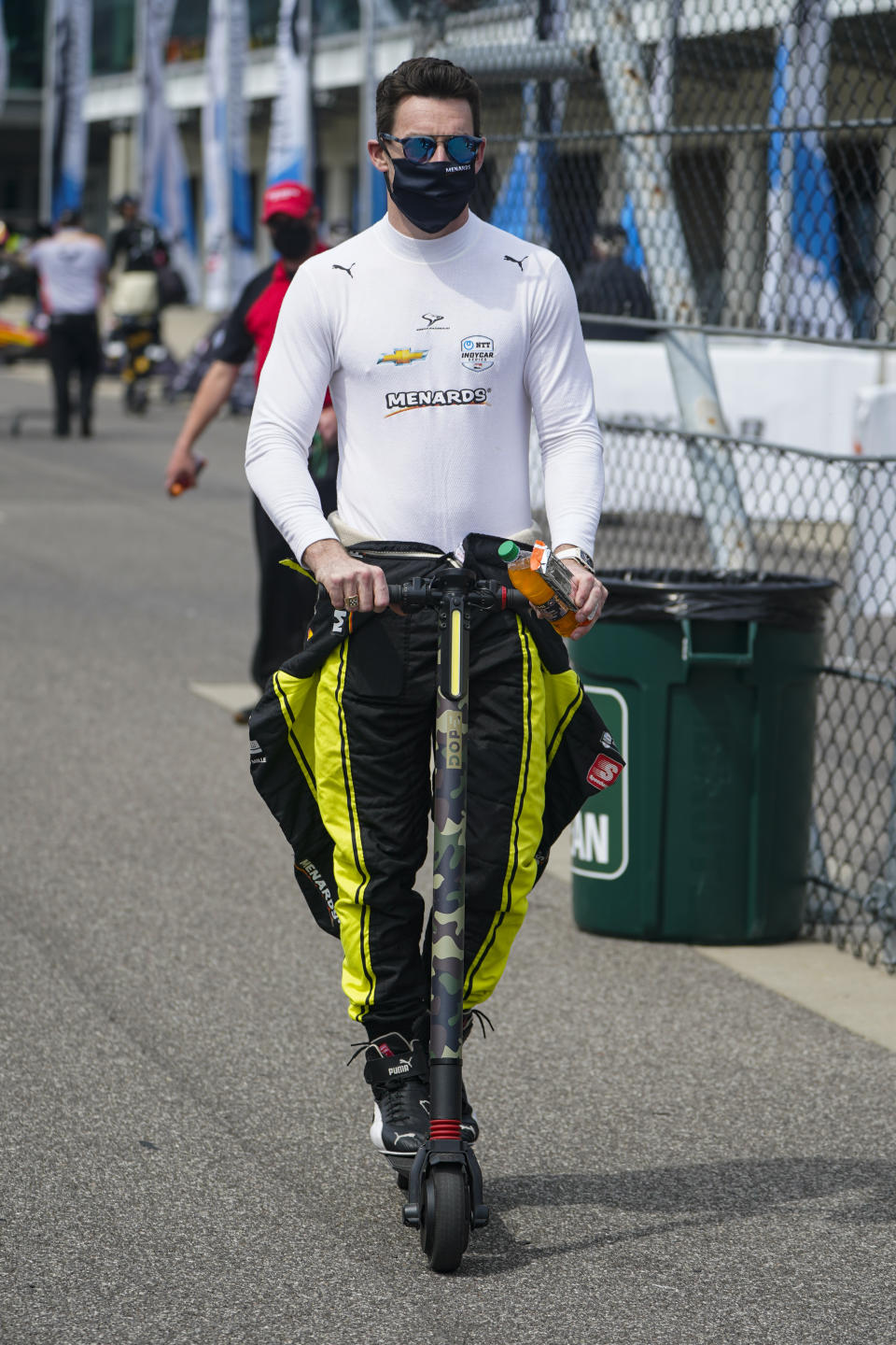 Simon Pagenaud of France rides a scooter through the pit area during practice for the Indianapolis 500 auto race at Indianapolis Motor Speedway in Indianapolis, Tuesday, May 18, 2021. (AP Photo/Michael Conroy)