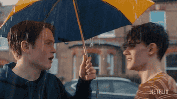 Toy boys under an umbrella with one saying, "Hi"