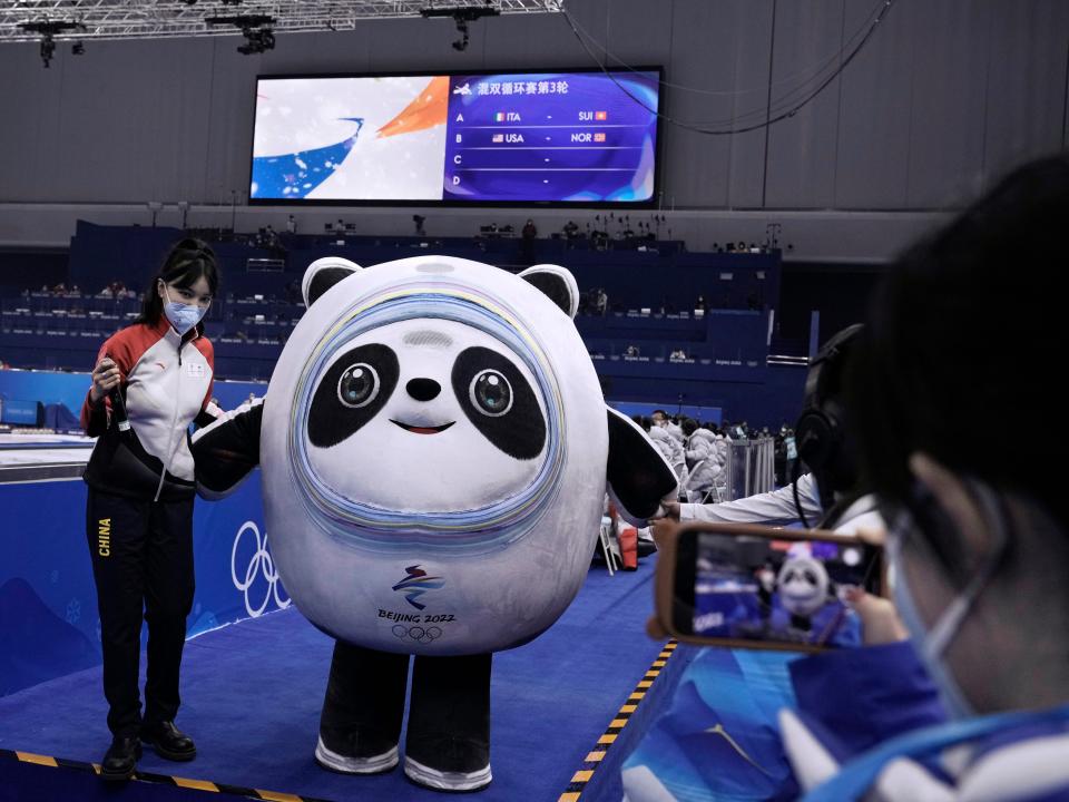 Volunteers take photographs with of Bing Dwen Dwen, the Beijing Winter Olympics mascot, at the curling venue for the 2022 Winter Olympics, Thursday, Feb. 3, 2022, in Beijing.