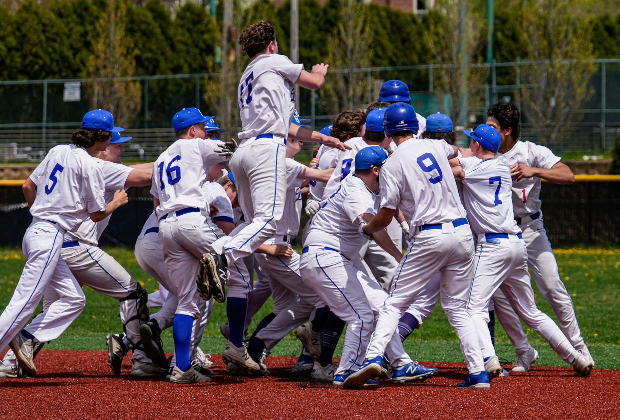 Whitefish Bay players swarm teammate DJ Kojis, obscured, after he hit a walk-off single at home against Arrowhead on Saturday, May 14, 2022. Whitefish Bay won 4-3.