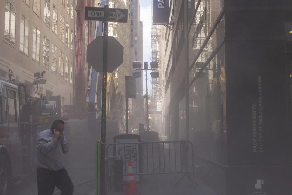 A street is covered in dust after facade of a partially collapsed parking garage is demolished in the Financial District of New York, Wednesday, April 19, 2023. (AP Photo/Yuki Iwamura)