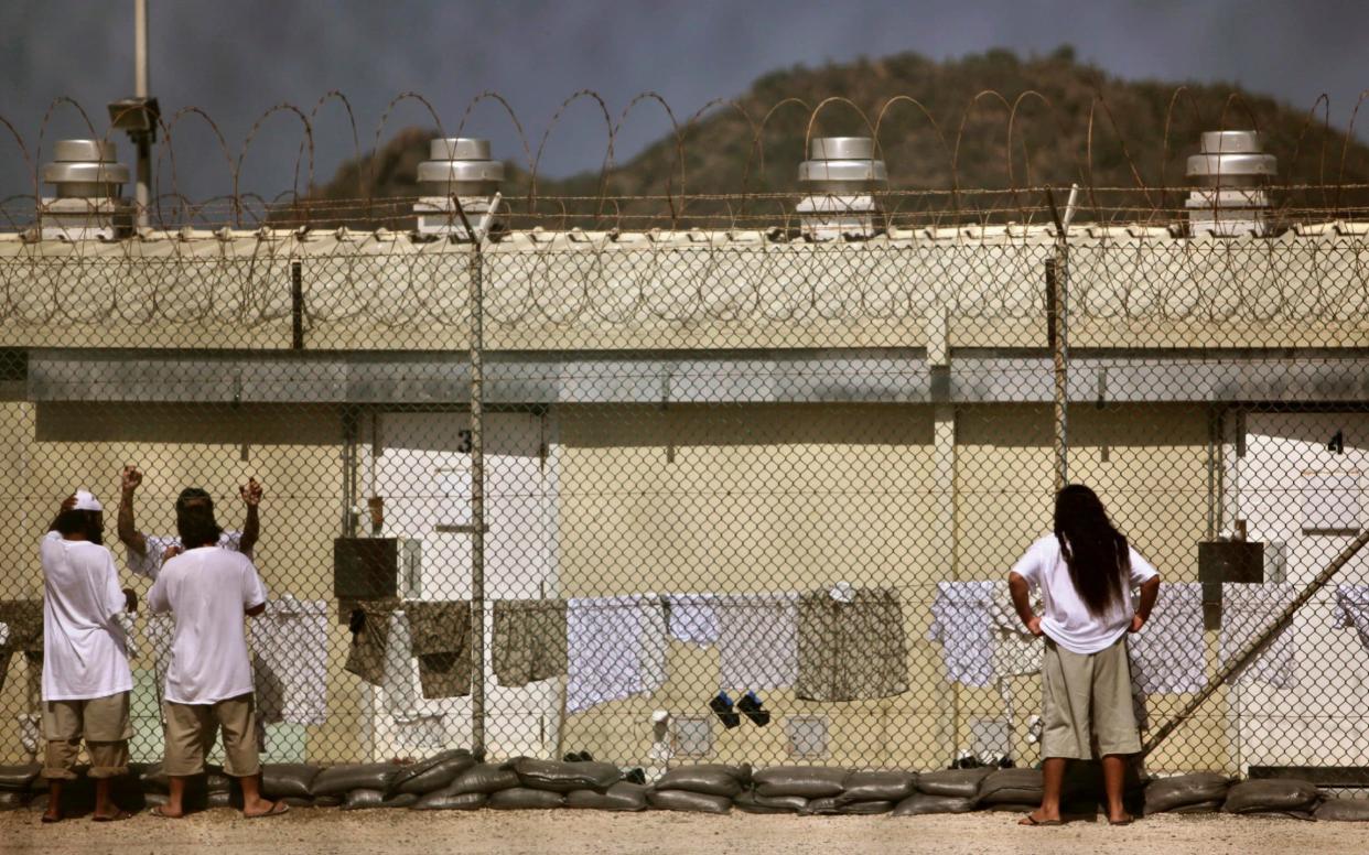 2009: Detainees talk together inside the open-air yard at the Camp 4 detention facility at Guantanamo Bay U.S. Naval Base in Cuba - REUTERS