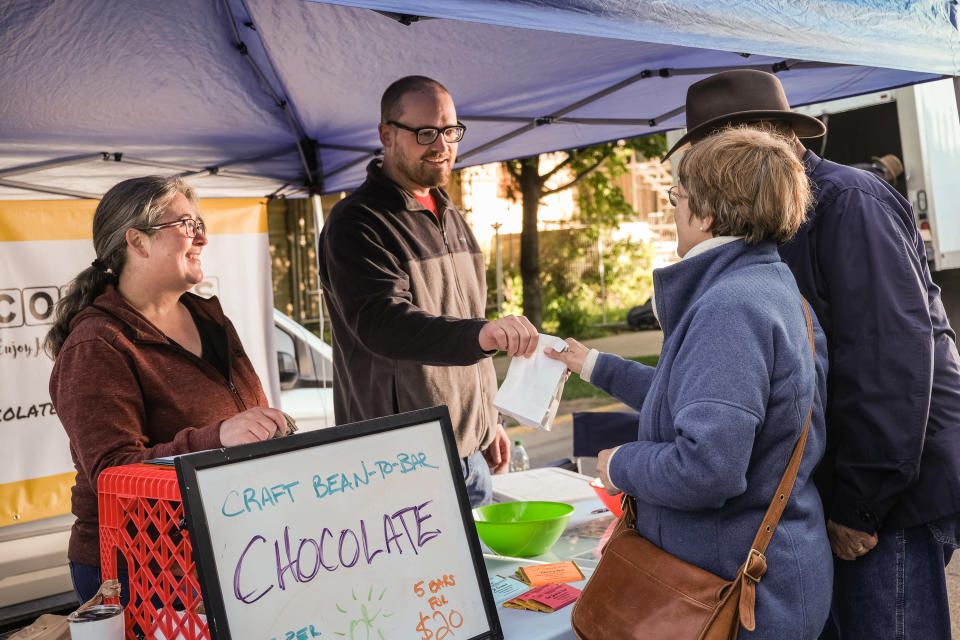Melody et Ian Karle vendent des tablettes de chocolat faites à la main au Great Falls Farmers' Market à Great Falls, dans le Montana, le 25 juin 2022. (Matthew Hamon/The New York Times)