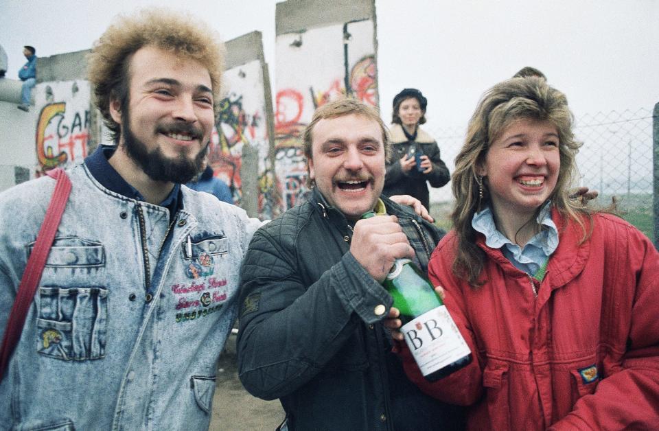 Bernd Mechelke of Ingolstadt, West Germany, welcomes his friends from Woltersdorf, East Germany, with a bottle of champagne as they arrive in West Berlin on Nov. 12, 1989.