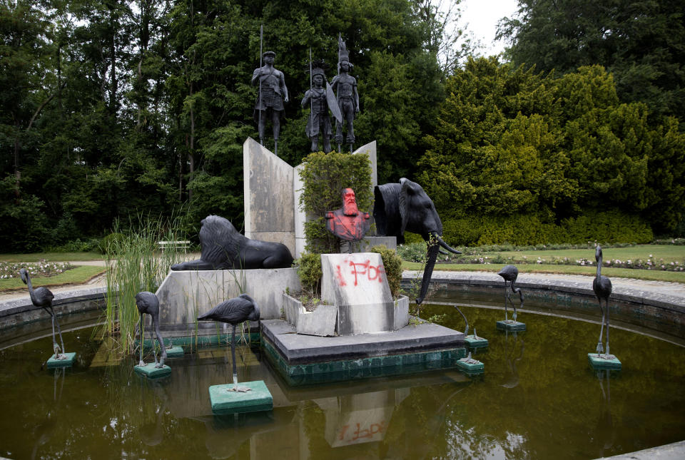 FILE - In this June 9, 2020 file photo, the bust of Belgium's King Leopold II is smeared with paint and graffiti on the grounds of the Royal Museum for Central Africa in Tervuren, Belgium. With the protests sweeping the world in the wake of the killing of George Floyd in Minneapolis, King Leopold II, who reigned from 1865 to 1909, is now increasingly seen as a stain on the nation. (AP Photo/Virginia Mayo, File)