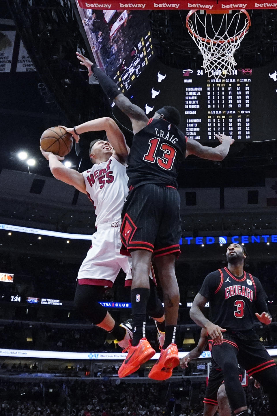 Miami Heat forward Duncan Robinson, left, shoots against Chicago Bulls forward Torrey Craig (13) during the first half of an NBA basketball game in Chicago, Saturday, Nov. 18, 2023. The Bulls won 102-97. (AP Photo/Nam Y. Huh)