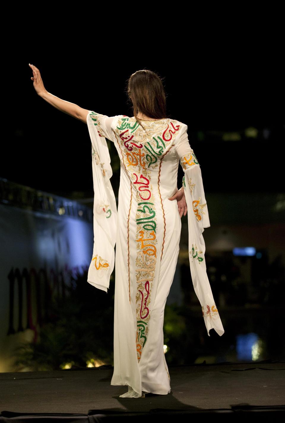 In this photo taken Friday, May 2, 2014, a model displays a creation with embroidered Arabic calligraphy by Jordanian-Palestinian designer Intisar Abdo during the second day of the Palestine Fashion Week 2014, in the West Bank city of Ramallah. Tamer Halabi, an organizer of the event, said the show in part shows that “we Palestinians exist.” and “We are surviving, we have talents, we have designers, and we can compete with world fashion houses." (AP Photo/Nasser Nasser)