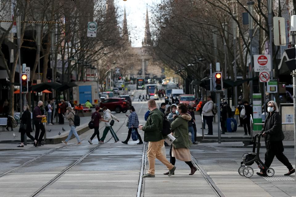 Melbourne residents cross a busy street.
