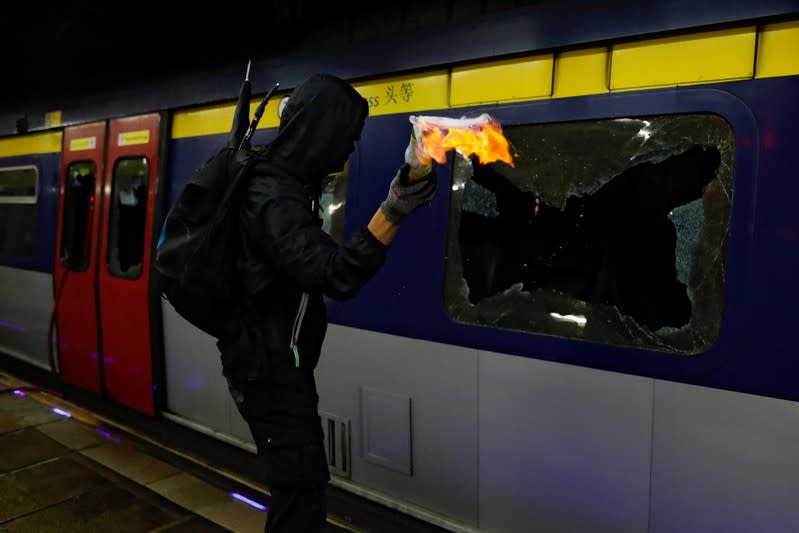 An anti-government protester throws a Molotov cocktail at the MTR University station during a protest at the Chinese University of Hong Kong, Hong Kong