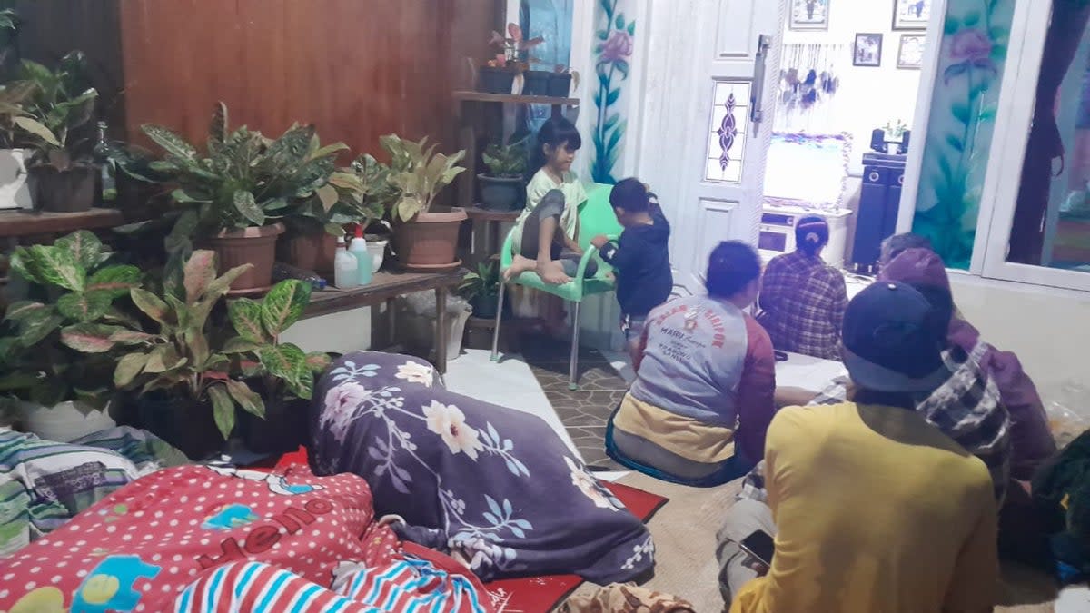 People stay outside of their house and hospital after a magnitude 7.3 earthquake occurred in their area in Muara Sikabaluan village, on Siberut Island  (AFP/Getty)