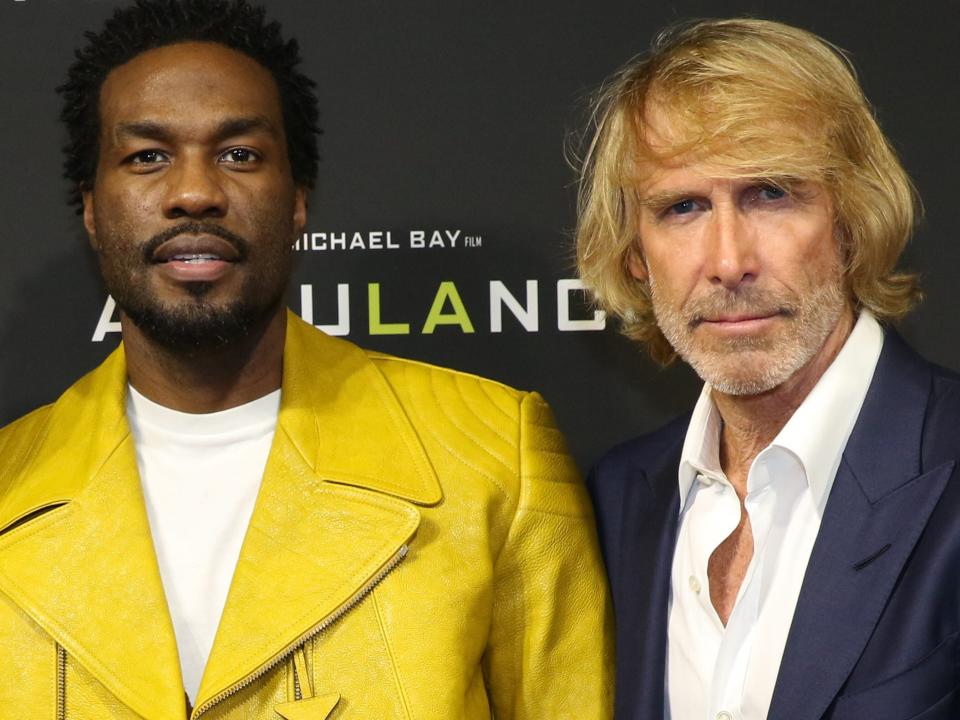 Yahya Abdul-Mateen II in yellow jacket, Michael Bay in blue suit