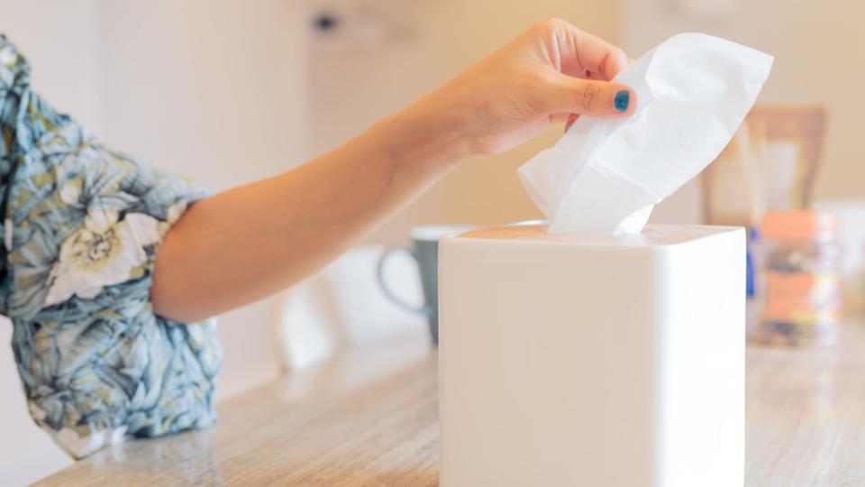 women hand picking napkin/tissue paper from the tissue box