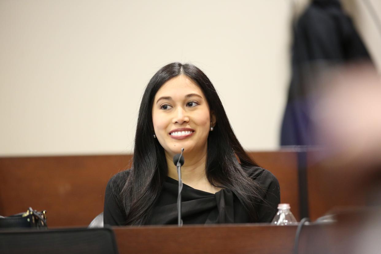 June Umchinda smiles at Charlie Adelson, her former boyfriend, from the witness stand, Oct. 27, 2023.