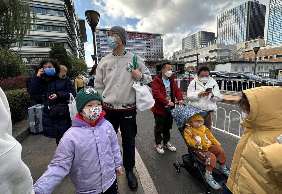 People and children leave a children’s hospital in Beijing, China (Reuters)