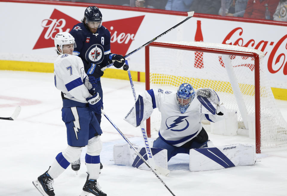 Winnipeg Jets' Adam Lowry (17) attempts to tip the puck past Tampa Bay Lightning goaltender Andrei Vasilevskiy (88) as Lightning's Haydn Fleury (7) defends during second-period NHL hockey game action in Winnipeg, Manitoba, Friday, Jan. 6, 2023. (John Woods/The Canadian Press via AP)