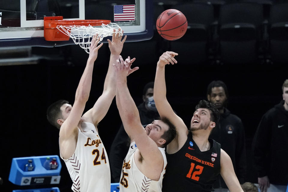 Oregon State center Roman Silva (12) fights for a rebound with Loyola Chicago guard Tate Hall (24) and center Cameron Krutwig, center, during the first half of a Sweet 16 game in the NCAA men's college basketball tournament at Bankers Life Fieldhouse, Saturday, March 27, 2021, in Indianapolis. (AP Photo/Jeff Roberson)