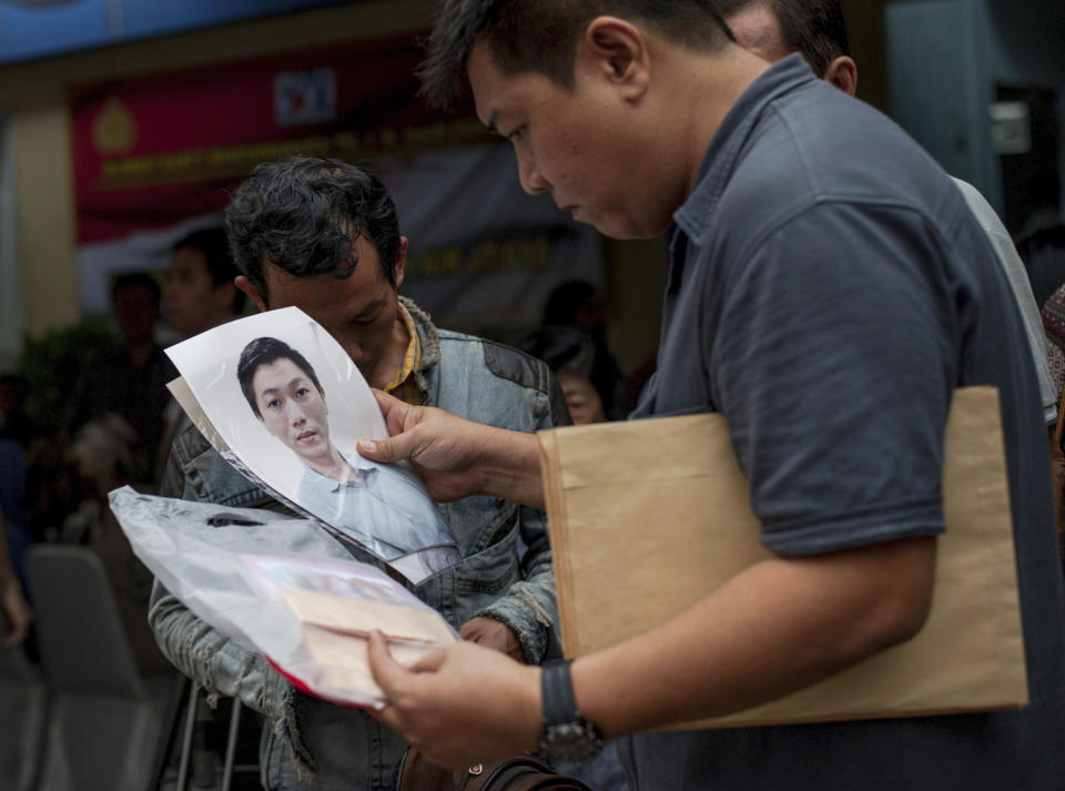 A relative holds a photo of a passenger of the crashed Lion Air plane at the police hospital in Jakarta, Indonesia. Image: AP