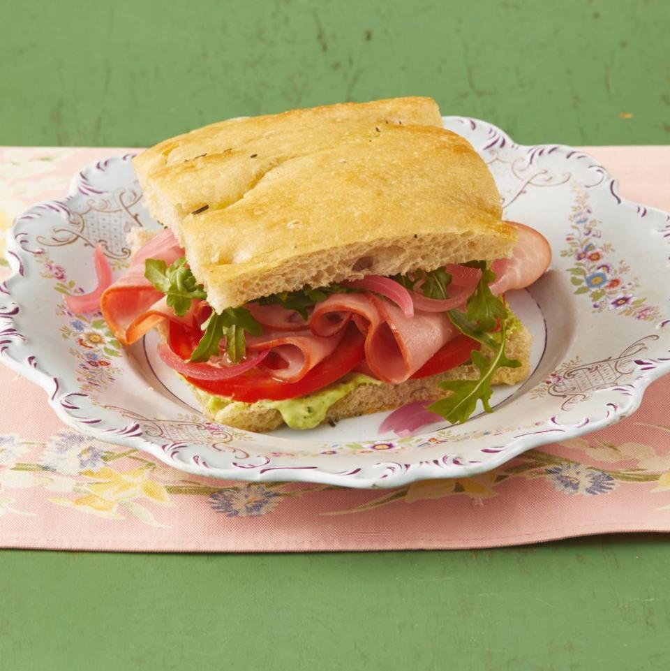 ham sandwiches with arugula and pesto mayo green background