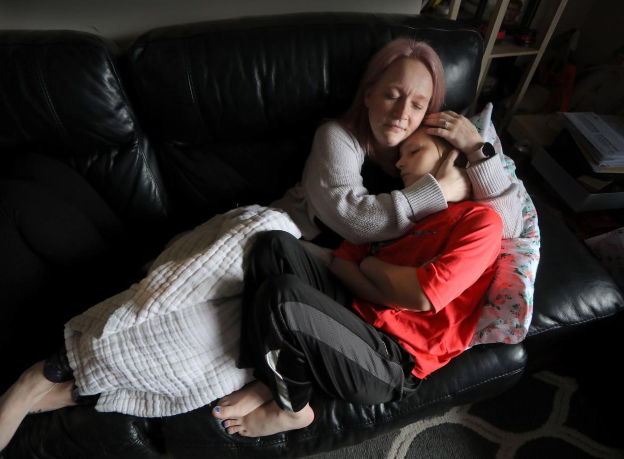 Rebekah Hogan lies with her son Sebastian, 9, in the living room of their home in Troy, N.Y. April 7, 2022. The family of five, including Rebekah's husband James, a disabled military veteran, contracted COVID-19 in late 2020. Almost a year and a half later, they all suffer symptoms of long COVID. New research from the University of Missouri has pinpointed specific symptoms of"long COVID," symptoms that linger months or years after the COVID virus has left their bodies.