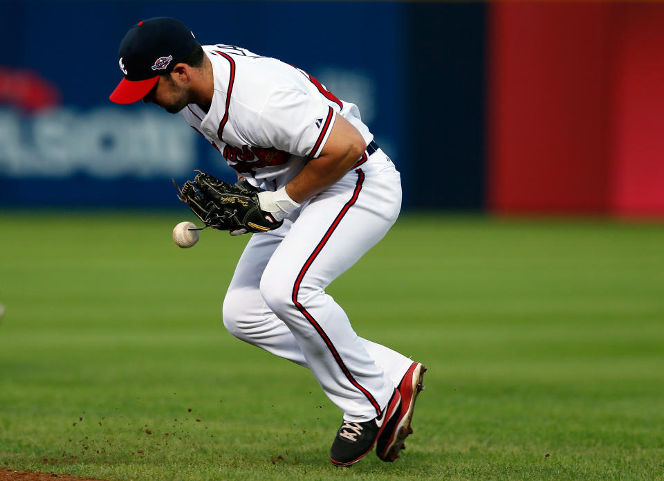 Dan Uggla #26 of the Atlanta Braves bobbles a groundball hit by David Freese #23 of the St. Louis Cardinals in the seventh inning during the National League Wild Card playoff game at Turner Field on October 5, 2012 in Atlanta, Georgia. (Photo by Kevin C. Cox/Getty Images)