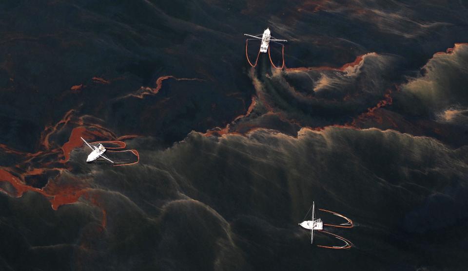 FILE - Shrimp boats are used to collect oil with booms in the waters of Chandeleur Sound, La., May 5, 2010. When a deadly explosion destroyed BP's Deepwater Horizon drilling rig in the Gulf of Mexico, tens of thousands of ordinary people were hired to help clean up the environmental devastation. (AP Photo/Eric Gay, File)