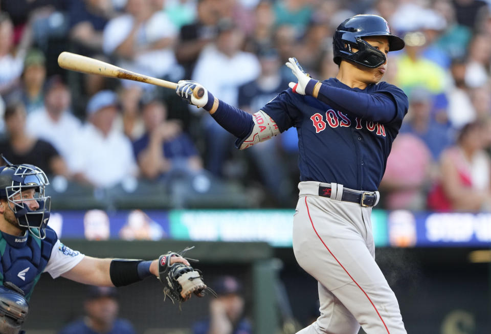 Boston Red Sox's Masataka Yoshida follows through on a double as Seattle Mariners catcher Cal Raleigh looks on during the fourth inning of a baseball game, Tuesday, Aug. 1, 2023, in Seattle. (AP Photo/Lindsey Wasson)