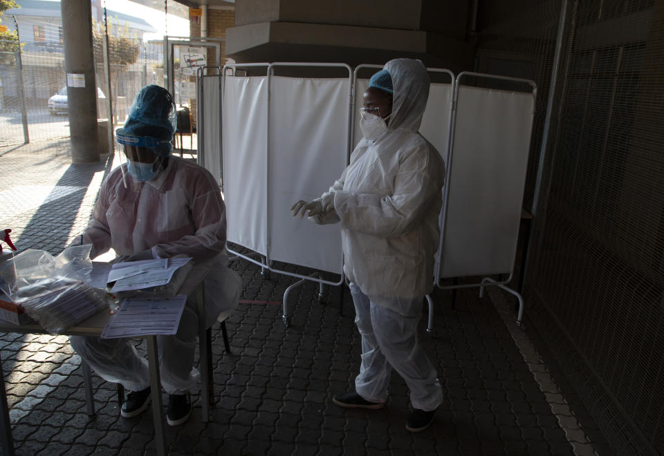 FILE - In this Tuesday, June 22, 2021 file photo, healthcare workers prepare to test patients for COVID-19 at the Lancet Laboratories in Johannesburg. Driven by the delta variant, a new wave of COVID-19 is sweeping across the African continent where new cases, hospital admissions, and deaths are increasing. (AP Photo/Denis Farrell, File)