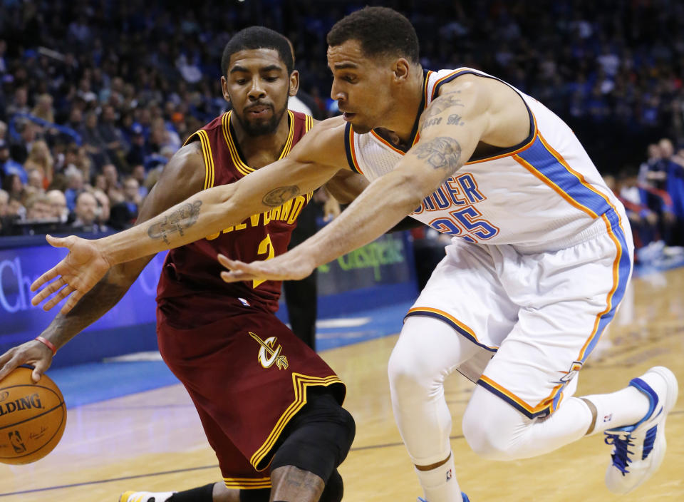 Cleveland Cavaliers guard Kyrie Irving (2) drives as Oklahoma City Thunder guard Thabo Sefolosha (25) reaches for the ball during the first quarter of an NBA basketball game in Oklahoma City, Wednesday, Feb. 26, 2014. (AP Photo/Sue Ogrocki)