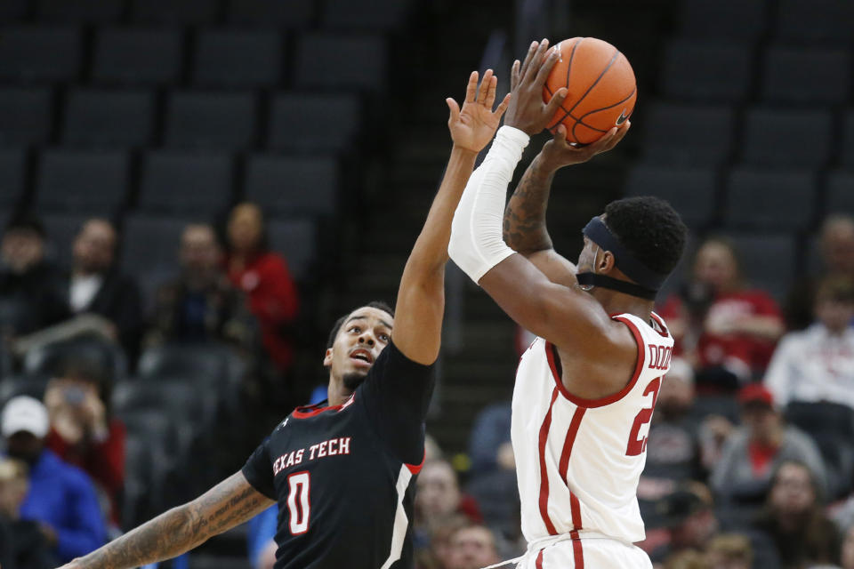 Oklahoma forward Kristian Doolittle, right, shoots over Texas Tech guard Kyler Edwards (0) in the second half of an NCAA college basketball game Tuesday, Feb. 25, 2020, in Oklahoma City. (AP Photo/Sue Ogrocki)