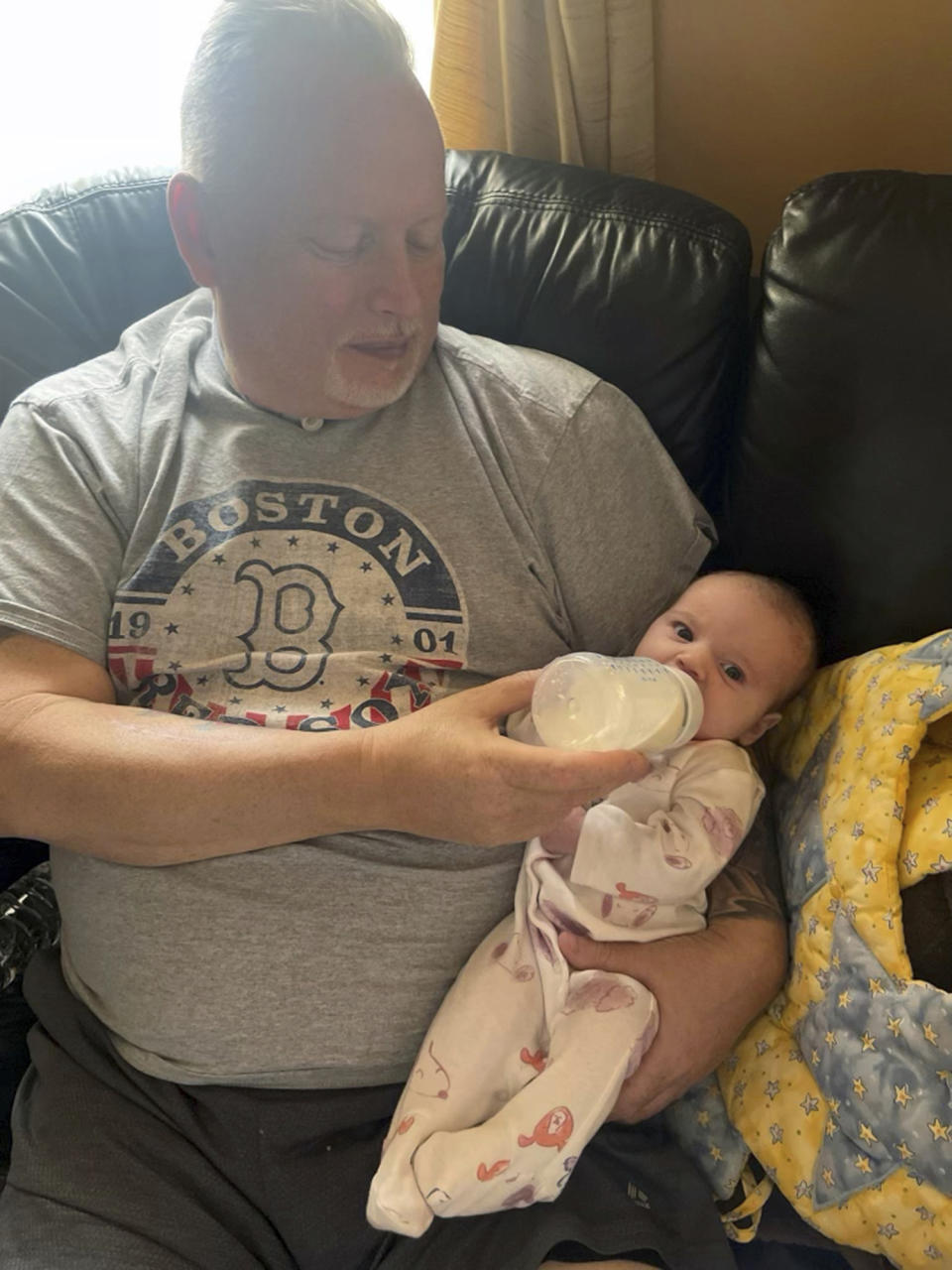 In this photo provided by the family, Marty Kedian holds his granddaughter in Pelham, N.H., on Feb. 26, 2023, before his larynx transplant. Kedian regained his voice after surgeons removed his cancerous larynx and, in a pioneering move, immediately replaced it with a donated one. (Family photo via AP)