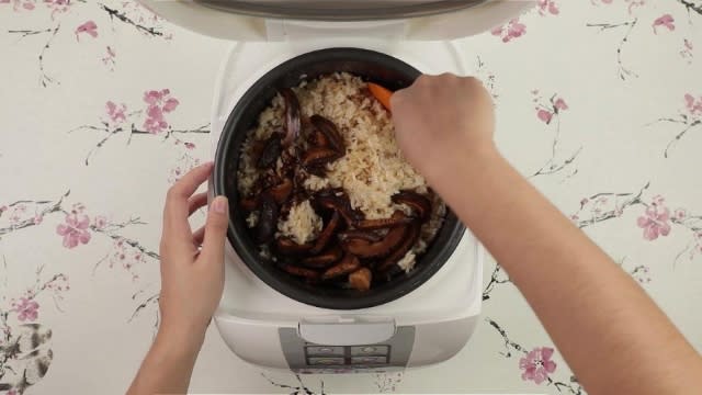 Mixing brown rice with mushrooms in rice cooker