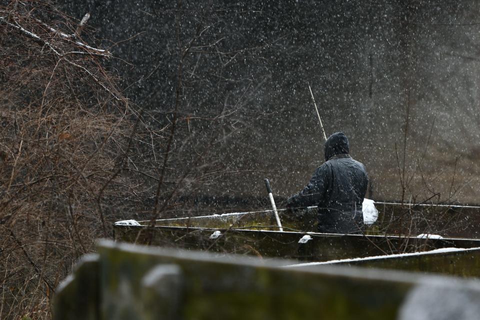 A man fishes the Red Cedar River near Potter Park Zoo, Friday afternoon, Jan. 12, 2024, as snow flurries begin to fall.
