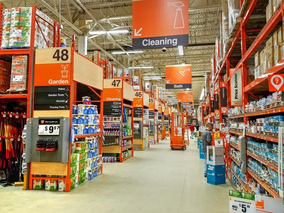 a main aisle of a home depot with several signs pointing down other aisles