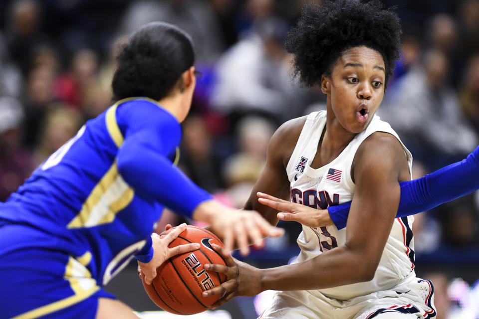 Connecticut's Christyn Williams (13) keeps the ball against the Tulsa defense during the second half of an NCAA college basketball game Sunday, Jan.19, 2020, in Storrs, Conn. (AP Photo/Stephen Dunn)