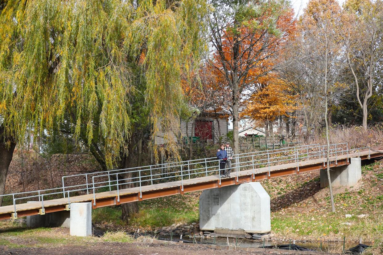 Judean and John Wise stand on their new  walking bridge over the Fond du Lac River which replaces one damaged by 2019 ice jams at the Wise residence on Grove Street in Fond du Lac. The 64-foot-long bridge is needed to connect land the couple owns on both sides of the river.