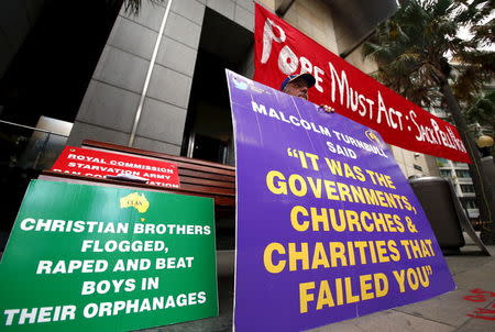 A man who claims to have been sexually abused by the Catholic Church holds a placard as he stands outside the venue for Australia's Royal Commission into Institutional Response to Child Sexual Abuse in Sydney, Australia, February 29, 2016. REUTERS/David Gray