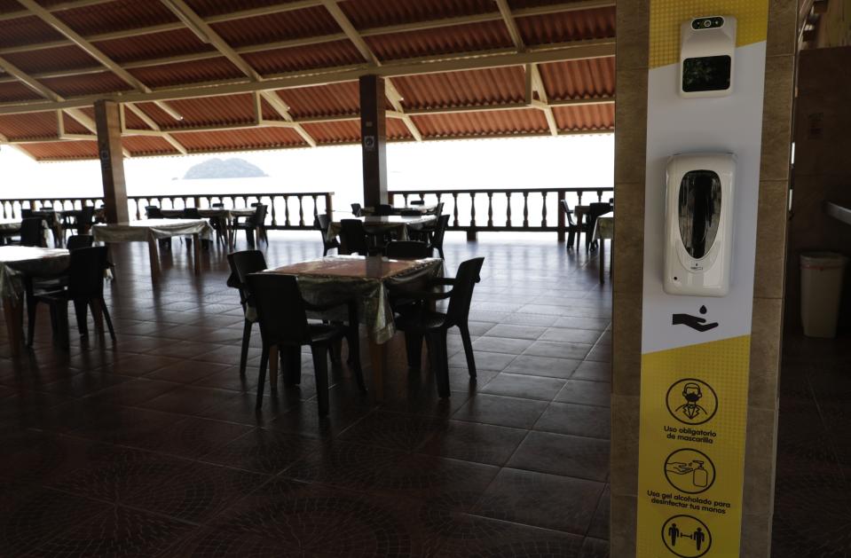 Una estación sanitaria está instalada en un restaurante un día antes de que las playas vuelvan a abrir oficialmente después de meses de bloqueo para contener la propagación del COVID-19, en Veracruz, en las afueras de la ciudad de Panamá, el viernes 23 de octubre de 2020. (AP Foto/Arnulfo Franco)