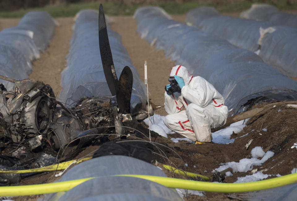 A person investigates the debris of a small plane at an asparagus field in the village Erzhausen near Frankfurt, Germany, Monday, April 1, 2019. Russian airline S7 Group said co-owner Natalia Fileva was aboard the single-engine, six-seat Epic LT aircraft that crashed and burned on Sunday, March 31, 2019, in a field as it approached the small airport at Egelsbach near Frankfurt. (Boris Roessler/dpa via AP)