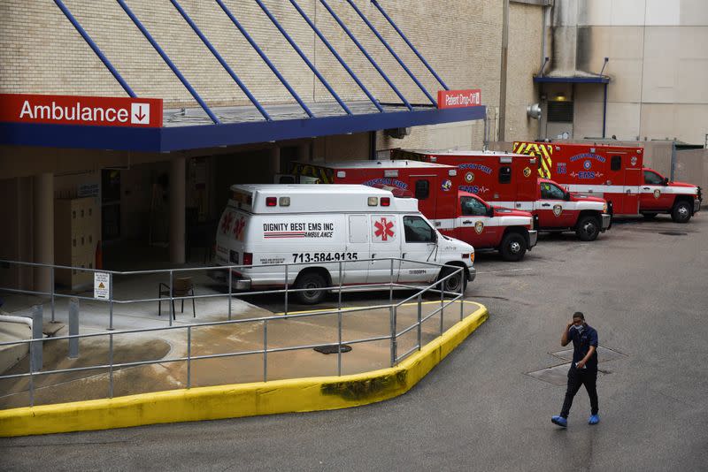 FOTO DE ARCHIVO: Un trabajador médico pasa junto a una fila de ambulancias estacionadas afuera del Hospital Metodista de Houston mientras las nubes de tormenta se acumulan sobre el Centro Médico de Texas, en medio del brote global de coronavirus en Houston, Texas, EEUU. 22 de junio de 2020