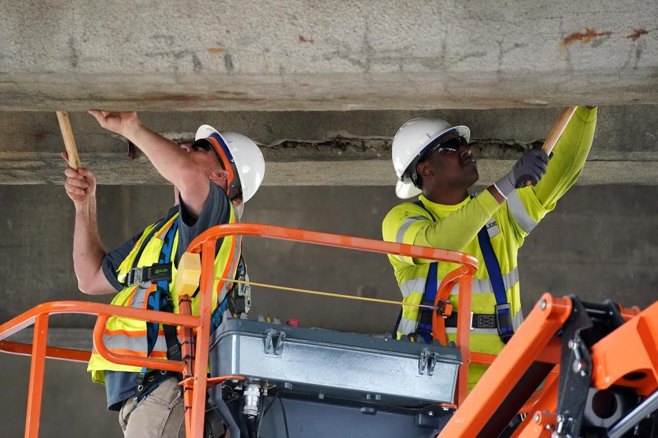 City workers and contractors send chunks of concrete from the underside of the Western Hill Viaduct's top deck to the lower deck as they perform maintenance work on the structure on Saturday.