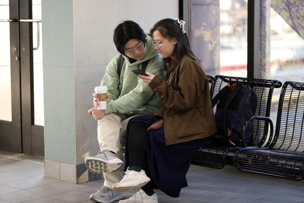 Jason Won, 25, left, of Mount Kisco, New York and Grace Pan, 23, of Mountain View, California wait for the 8:03 a.m. train to Syracuse to view the total solar eclipse April 8, 2024 at the Croton-Harmon station in Croton-on-Hudson, New York. "I've seen partial eclipses before," Won said. "They were pretty cool. Nothing really, like, life-changing. So I'm really hoping for something big."