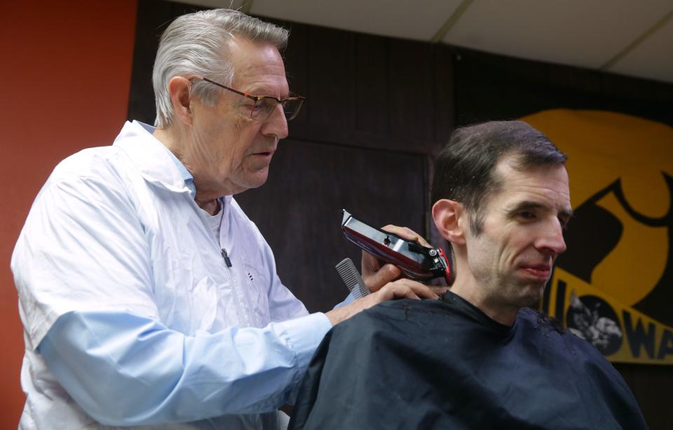 Tom Bergman cuts Matthew Witry's hair Wednesday, Dec. 13, 2023 in Iowa City, Iowa. Bergman is retiring at the end of the month.