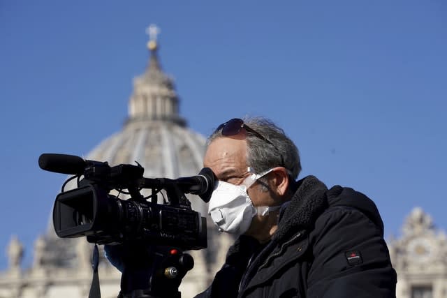A cameraman wearing a mask films in St Peter’s Square at the Vatican