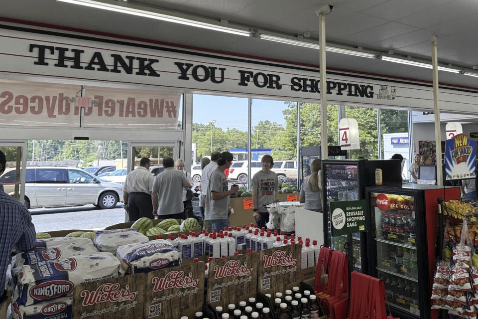 Employees work the checkout lines of the Mad Butcher grocery store in Fordyce, Arkansas on Tuesday, July 2, 2024. The grocery store reopened on Tuesday, 11 days after a shooter killed four people and injured 10 others in in the store and its parking lot. (AP Photo/Andrew DeMillo)