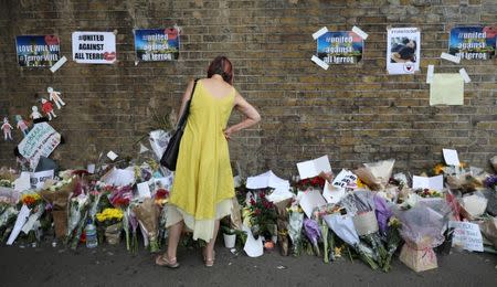 A woman looks at messages at the base of a wall near the scene of an attack next to Finsbury Park Mosque, in north London, Britain June 20, 2017. REUTERS/Marko Djurica