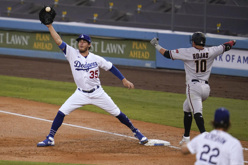 Los Angeles Dodgers starting pitcher Clayton Kershaw, bottom right, throws to first baseman Cody Bellinger to put out Arizona Diamondbacks' Josh Rojas on a ground ball during the second inning of a baseball game Thursday, Sept. 3, 2020, in Los Angeles. (AP Photo/Marcio Jose Sanchez)