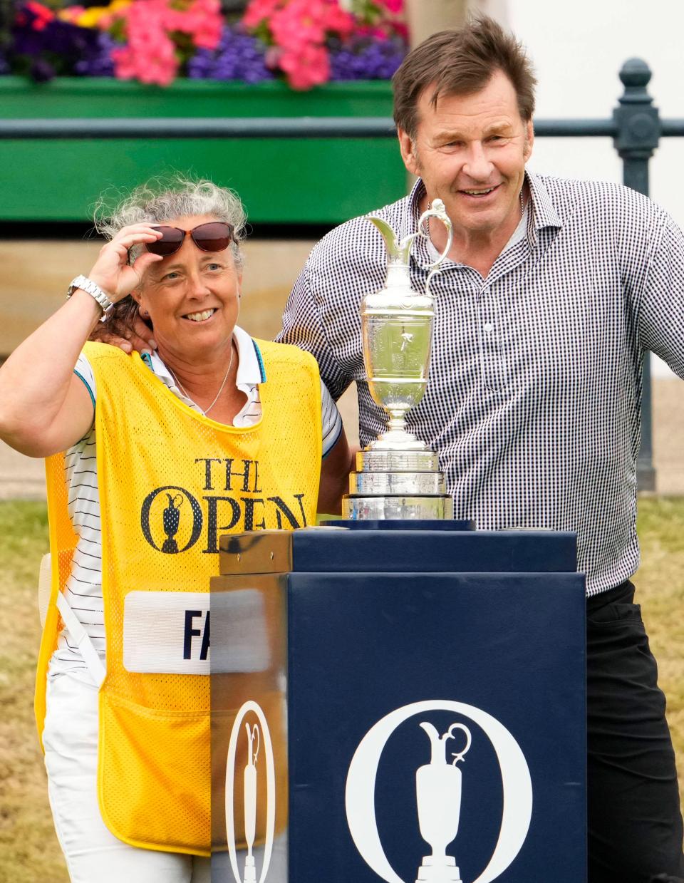 Jul 11, 2022; St. Andrews, SCT; Caddie Fanny Sunesson and Sir Nick Faldo pose for a photograph with the Claret Jug during the R&A Celebration of Champions four-hole challenge at the 150th Open Championship golf tournament at St. Andrews Old Course.