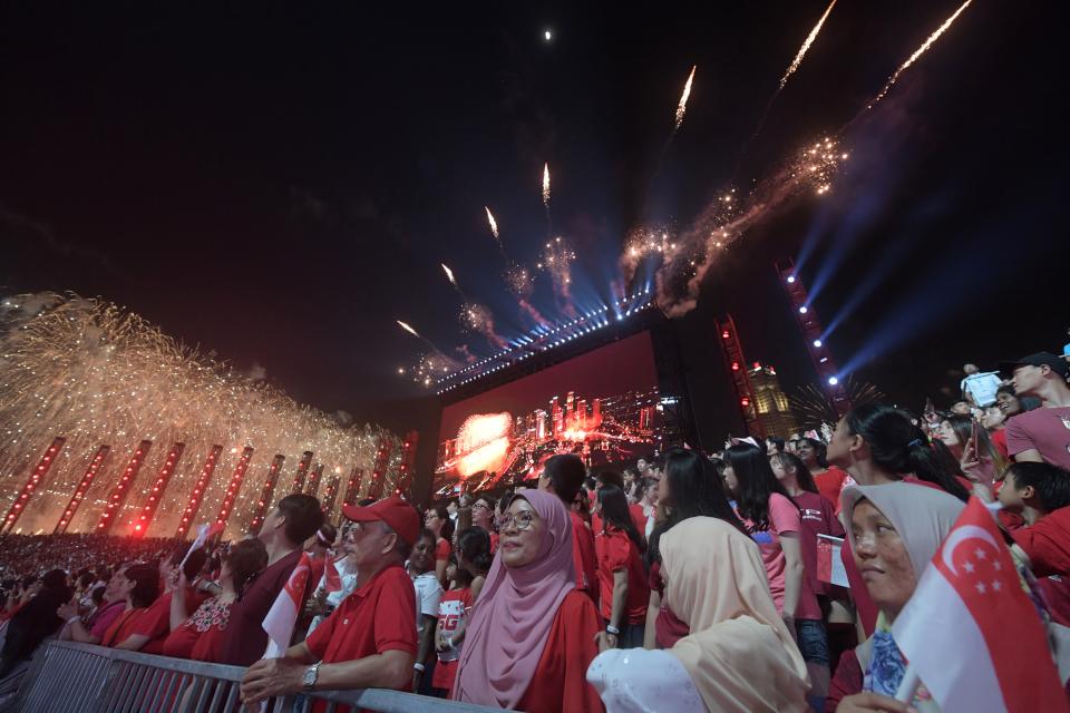 TOPSHOT - Spectators react as fireworks explode during the 54th National Day Parade in Singapore on August 9, 2019. (Photo by Roslan RAHMAN / AFP)        (Photo credit should read ROSLAN RAHMAN/AFP/Getty Images)