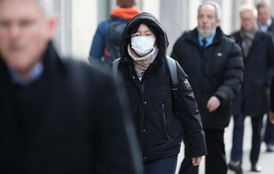A pedestrian wears a face mask whilst walking along High Holborn in central London (PA)