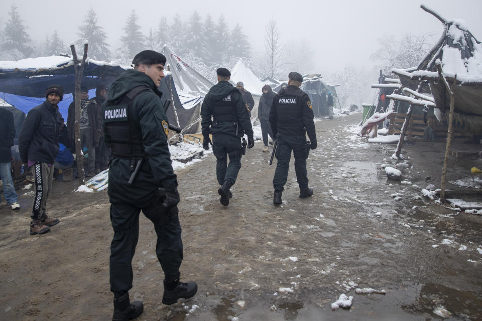 Bosnian police moves through the Vucjak refugee camp outside Bihac, northwestern Bosnia, Tuesday, Dec. 3, 2019. A European human rights official has demanded immediate closure of a migrant camp in Bosnia where hundreds of people have started refusing food and water to protest dismal living conditions as wintry weather sets in. (AP Photo/Darko Bandic)